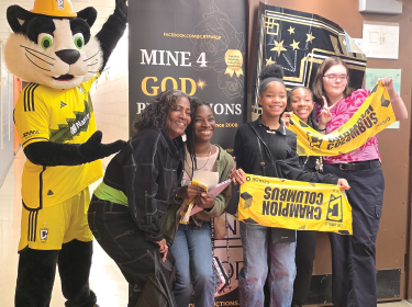 students posing with Columbus Crew mascot, Crew Cat